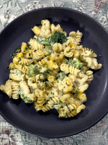 A plate of cheesy noodles made with spiral noodles, cheese and brocoli