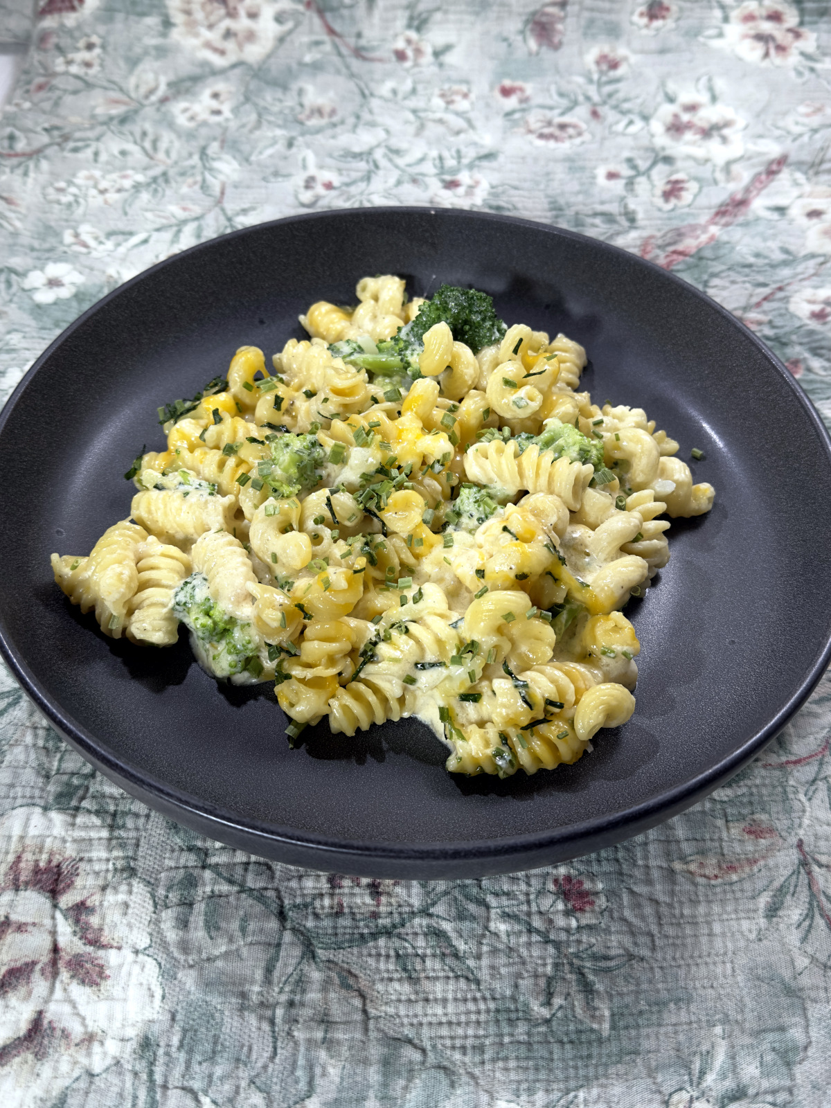 A plate of cheesy fusilli noodles, cheese and broccoli.