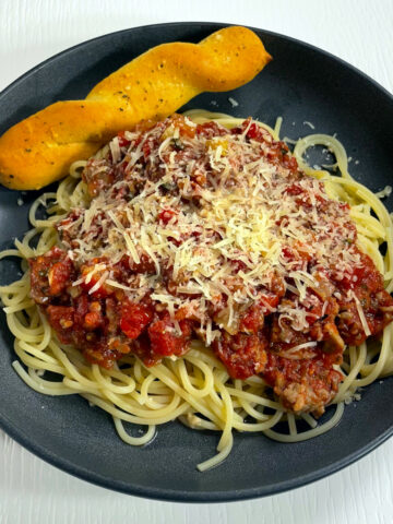 A plate of our favorite spaghetti. Topped with meat sauce and shredded parmesan cheese.